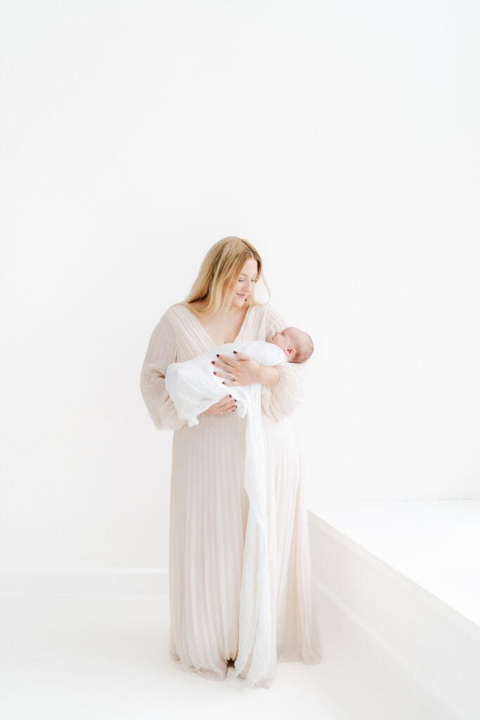 Baby cuddled in mum's arms during a baby photography session in Westbury, Wiltshire.