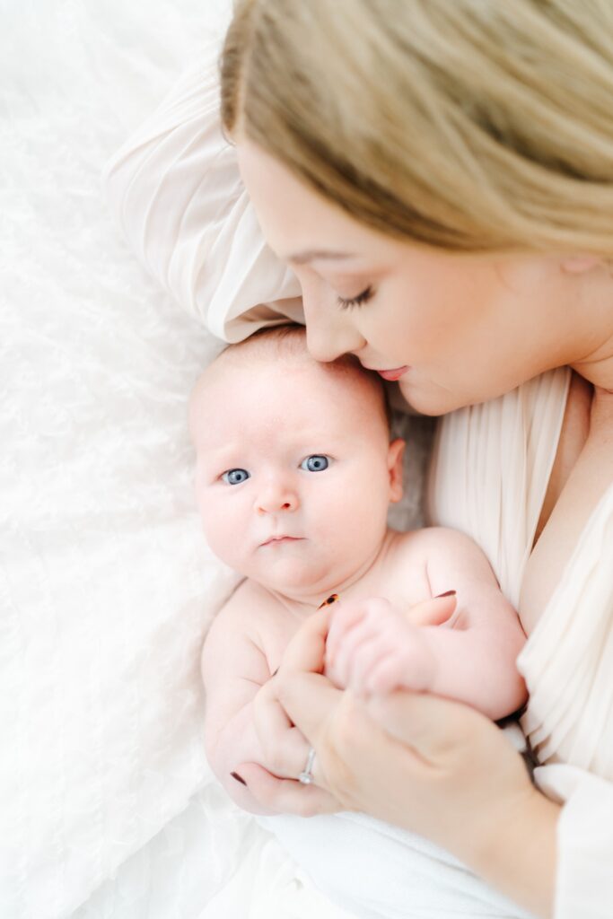 Baby cuddled close to Mum during a timeless and relaxed baby photography session in Westbury.