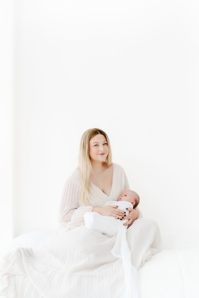 Baby peacefully cuddled in Mum's arms during an 8-week baby photography session at my Westbury studio.