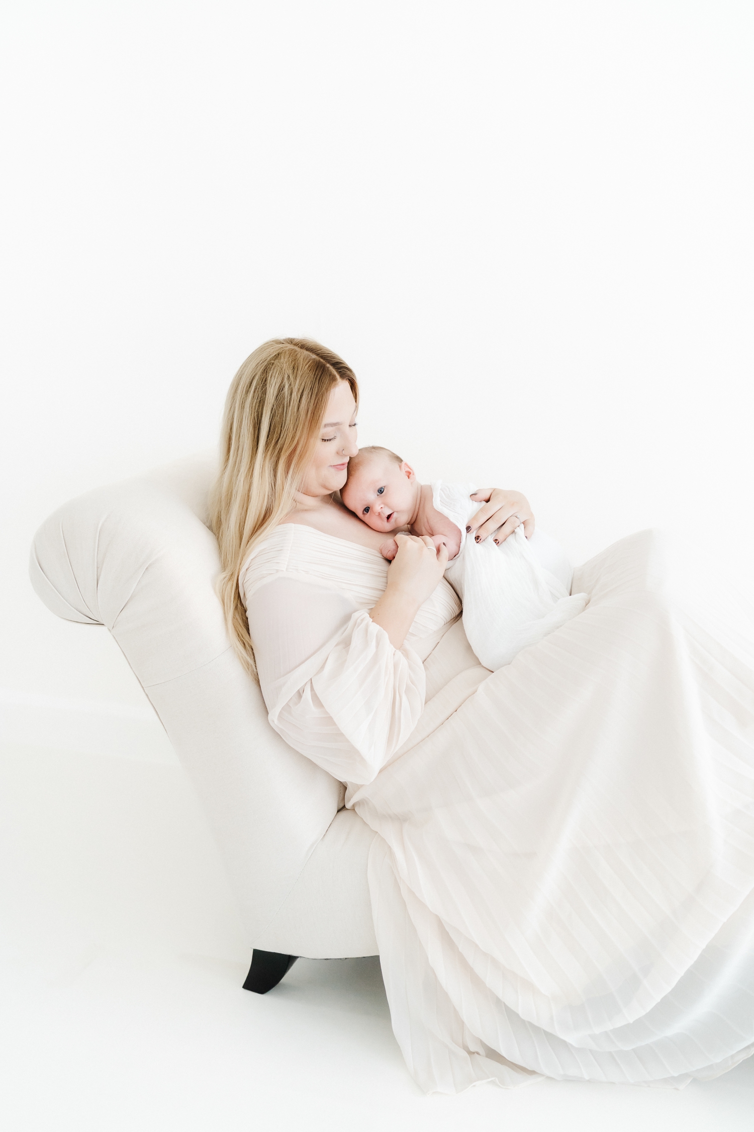 Mum enjoying quiet newborn cuddles with her baby during a light and airy baby photography session in Wiltshire.