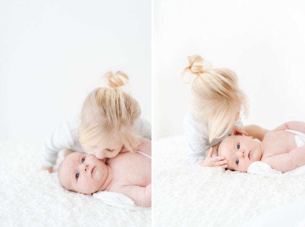 Big sister kissing her baby brother during a baby photography session in Wiltshire